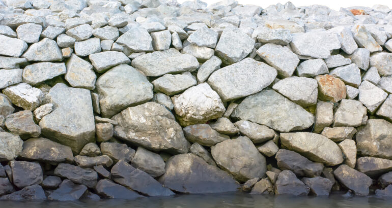 Stones of different sizes overlap, called seawall.
