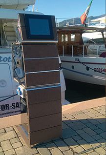 Leonardo power pedestal with a built-in touch screen monitor standing on a marina dock beside moored yachts.